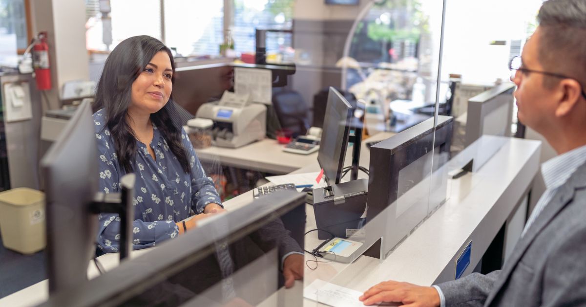 Bank teller processing a transaction for a customer